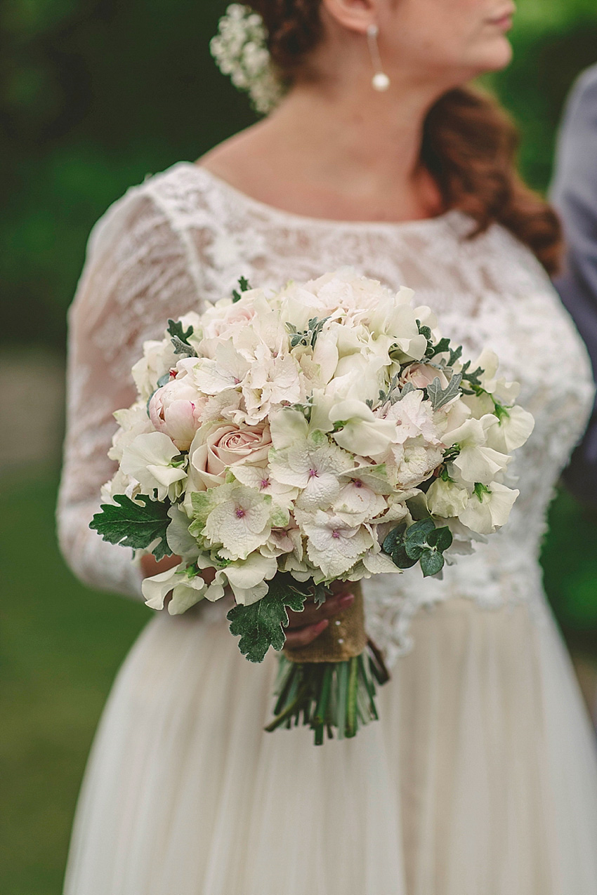 The bride wore a Watters wedding dress for her wedding at The Great Barn at Micklefield Hall in Hertfordshire. The bridesmaids wore navy blue. Photography by Benjamin Stuart.