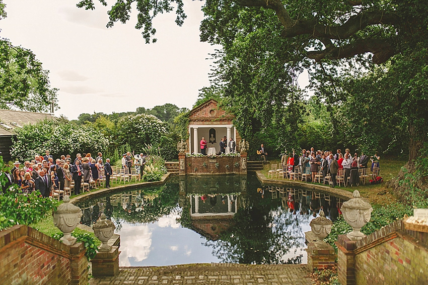 The bride wore a Watters wedding dress for her wedding at The Great Barn at Micklefield Hall in Hertfordshire. The bridesmaids wore navy blue. Photography by Benjamin Stuart.