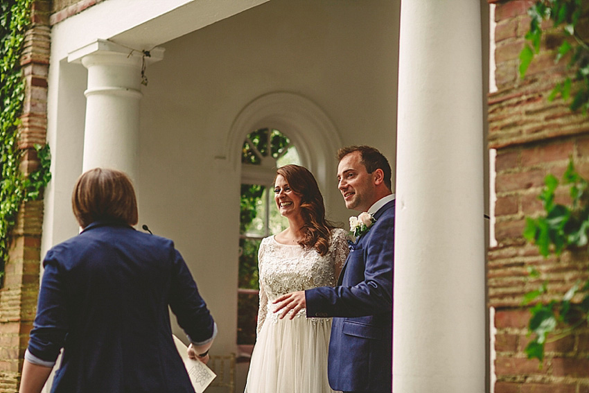 The bride wore a Watters wedding dress for her wedding at The Great Barn at Micklefield Hall in Hertfordshire. The bridesmaids wore navy blue. Photography by Benjamin Stuart.