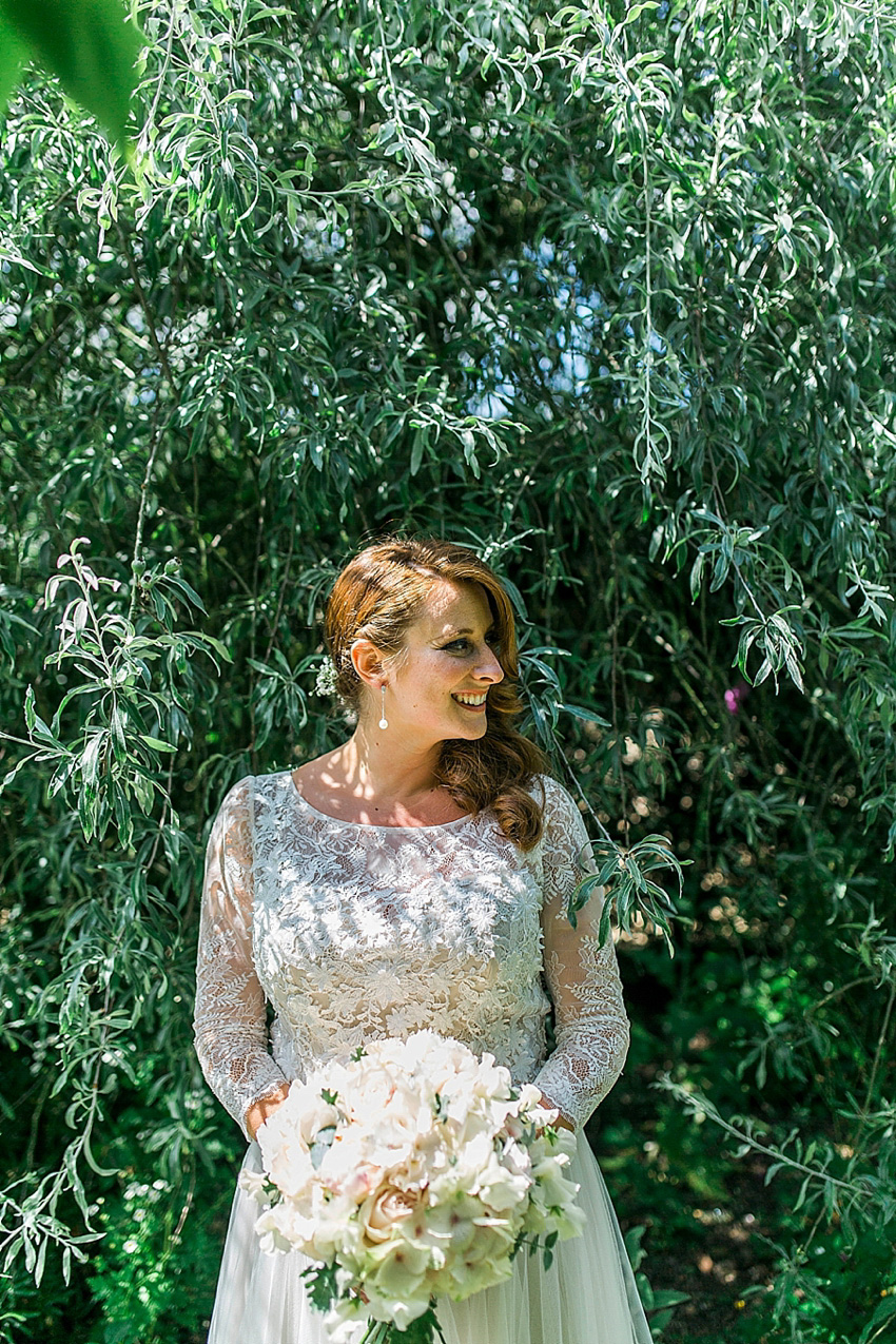 The bride wore a Watters wedding dress for her wedding at The Great Barn at Micklefield Hall in Hertfordshire. The bridesmaids wore navy blue. Photography by Benjamin Stuart.