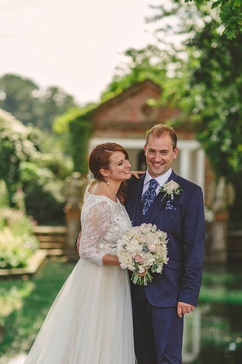 The bride wore a Watters wedding dress for her wedding at The Great Barn at Micklefield Hall in Hertfordshire. The bridesmaids wore navy blue. Photography by Benjamin Stuart.