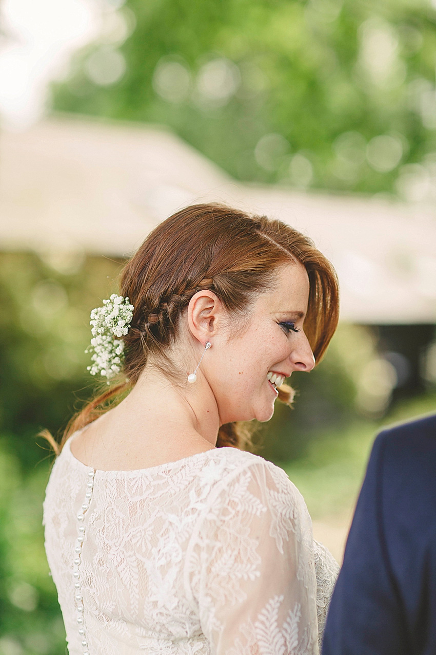 The bride wore a Watters wedding dress for her wedding at The Great Barn at Micklefield Hall in Hertfordshire. The bridesmaids wore navy blue. Photography by Benjamin Stuart.