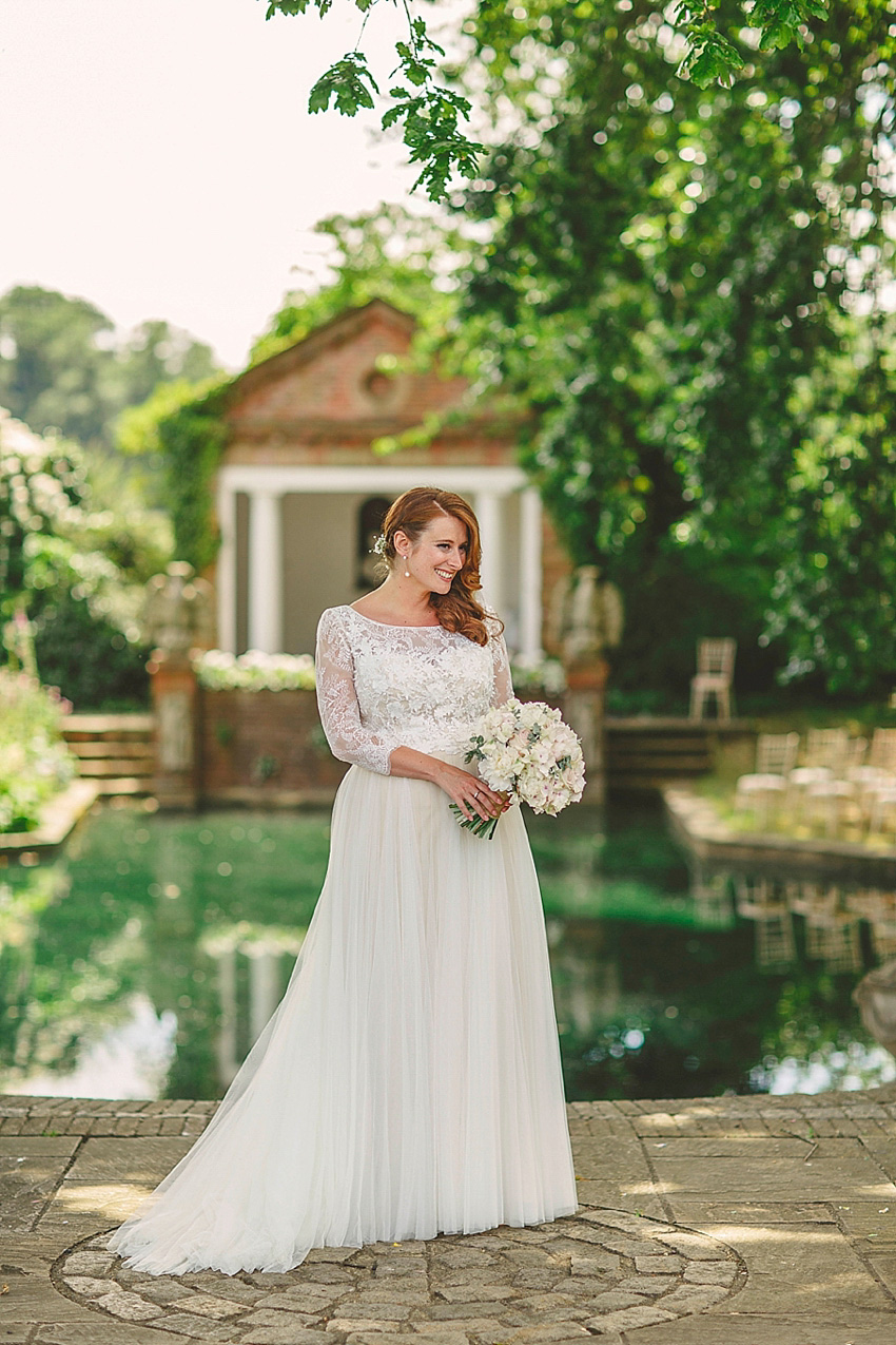 The bride wore a Watters wedding dress for her wedding at The Great Barn at Micklefield Hall in Hertfordshire. The bridesmaids wore navy blue. Photography by Benjamin Stuart.