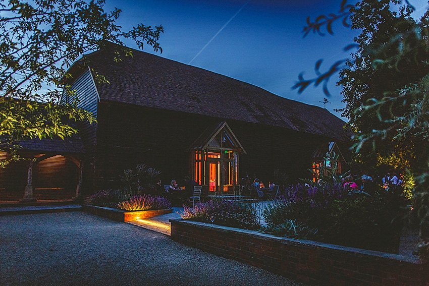 The bride wore a Watters wedding dress for her wedding at The Great Barn at Micklefield Hall in Hertfordshire. The bridesmaids wore navy blue. Photography by Benjamin Stuart.