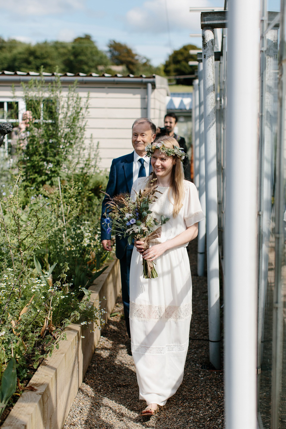 A Humanist handfasting outdoor ceremony at The Secret Herb Garden, just outside Edinburgh. The bride wore 'Minna'. Photography by Caro Weiss.