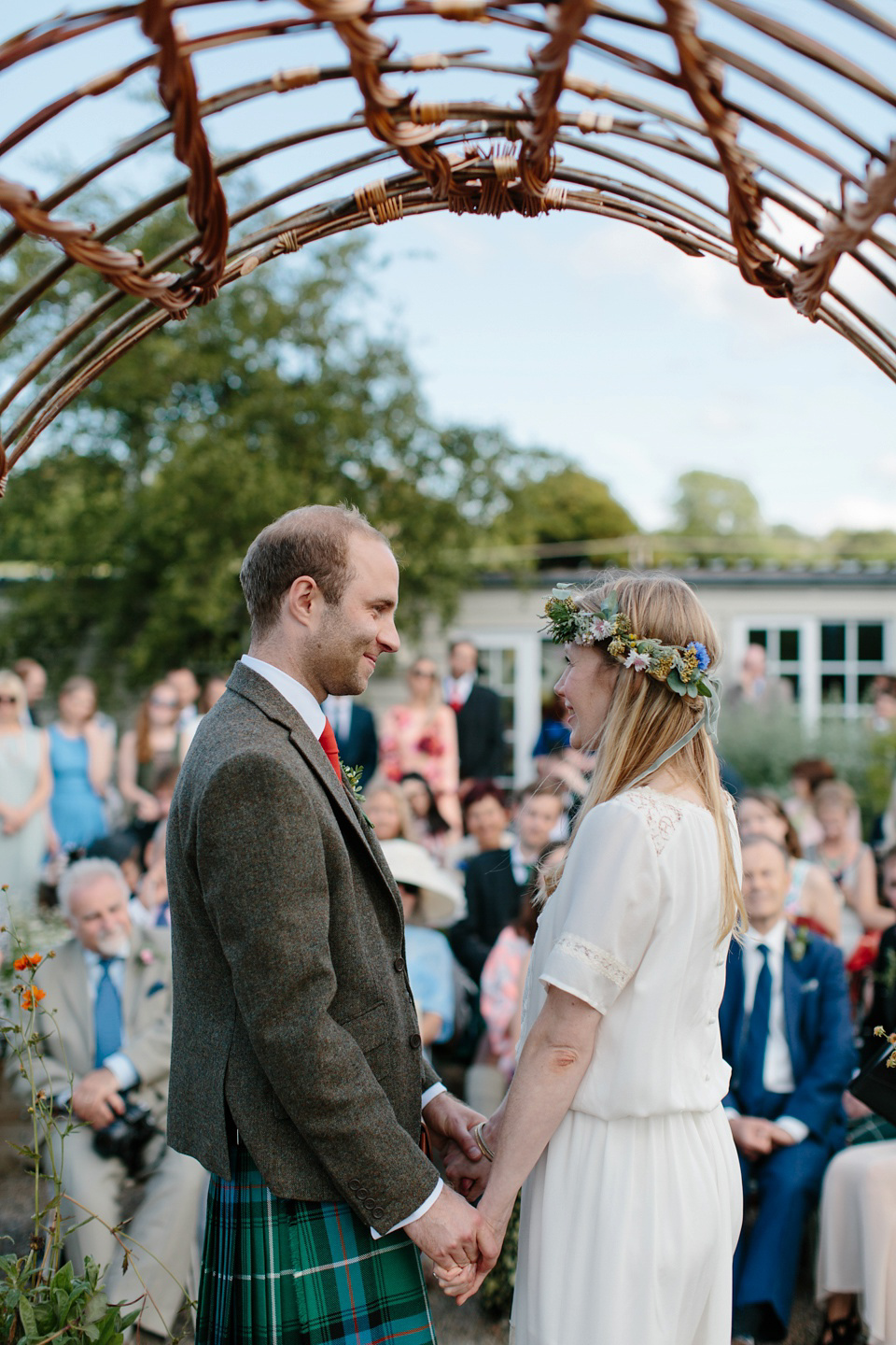 A Humanist handfasting outdoor ceremony at The Secret Herb Garden, just outside Edinburgh. The bride wore 'Minna'. Photography by Caro Weiss.