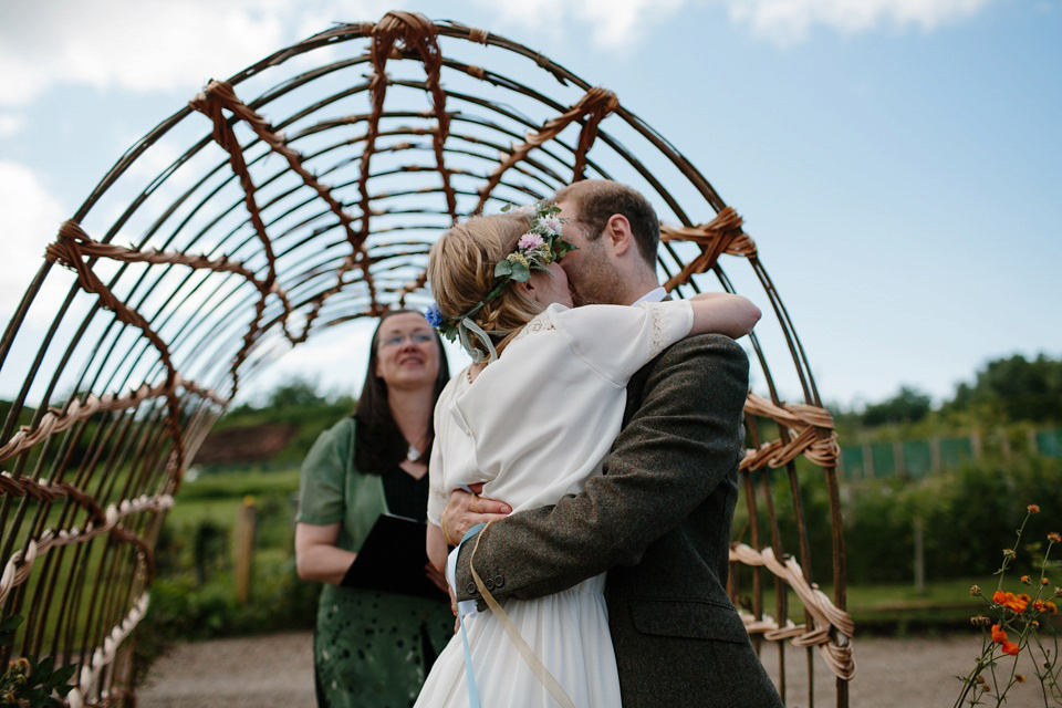 A Humanist handfasting outdoor ceremony at The Secret Herb Garden, just outside Edinburgh. The bride wore 'Minna'. Photography by Caro Weiss.