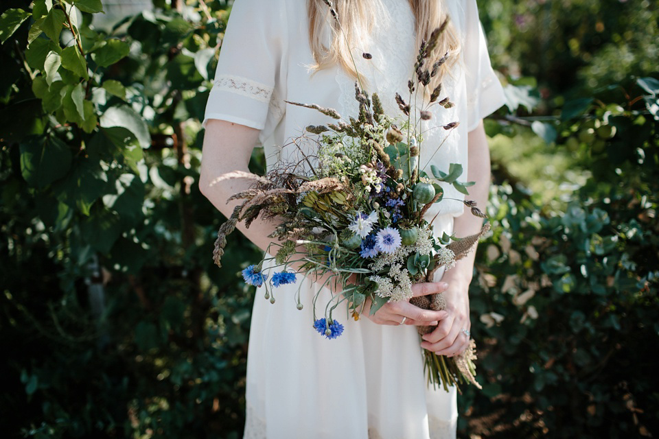 A Humanist handfasting outdoor ceremony at The Secret Herb Garden, just outside Edinburgh. The bride wore 'Minna'. Photography by Caro Weiss.