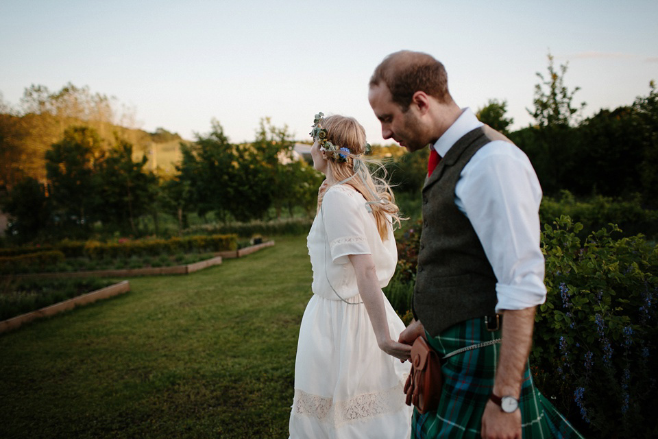 A Humanist handfasting outdoor ceremony at The Secret Herb Garden, just outside Edinburgh. The bride wore 'Minna'. Photography by Caro Weiss.