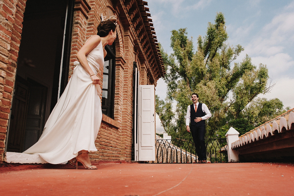 A sophisticated asymmetric dress and sweet first look for a colourful outdoor wedding in Spain. Photography by This Modern Love.