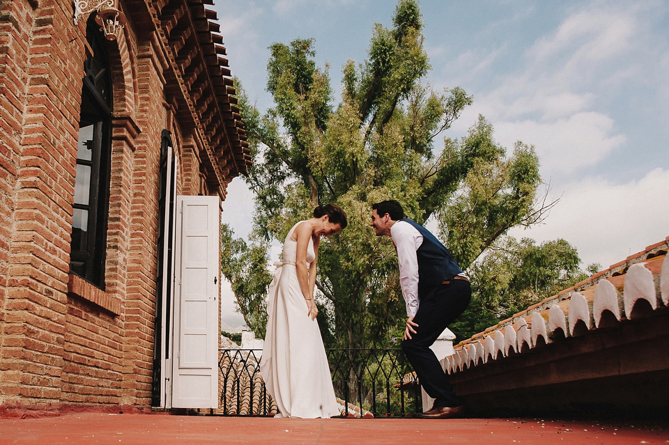 A sophisticated asymmetric dress and sweet first look for a colourful outdoor wedding in Spain. Photography by This Modern Love.