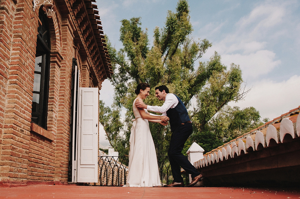 A sophisticated asymmetric dress and sweet first look for a colourful outdoor wedding in Spain. Photography by This Modern Love.