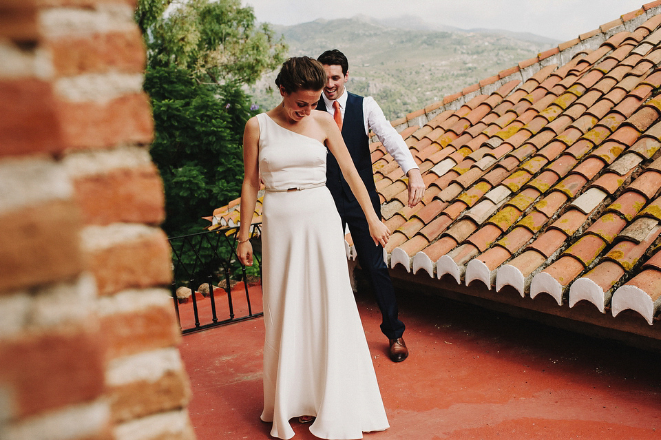 A sophisticated asymmetric dress and sweet first look for a colourful outdoor wedding in Spain. Photography by This Modern Love.