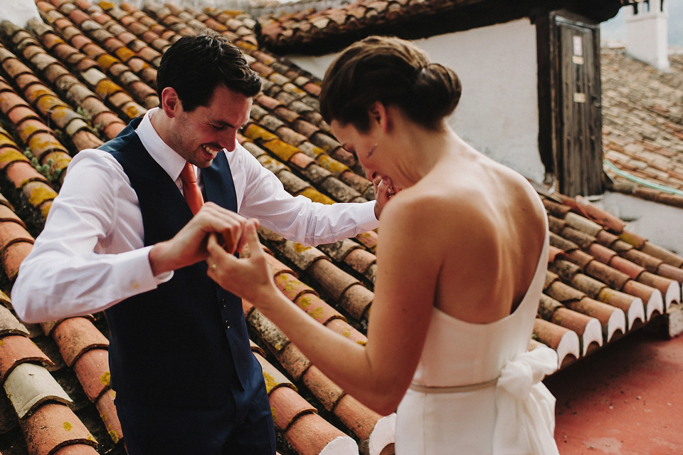 A sophisticated asymmetric dress and sweet first look for a colourful outdoor wedding in Spain. Photography by This Modern Love.