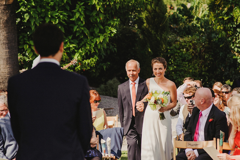 A sophisticated asymmetric dress and sweet first look for a colourful outdoor wedding in Spain. Photography by This Modern Love.