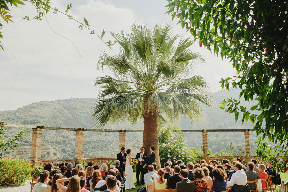 A sophisticated asymmetric dress and sweet first look for a colourful outdoor wedding in Spain. Photography by This Modern Love.