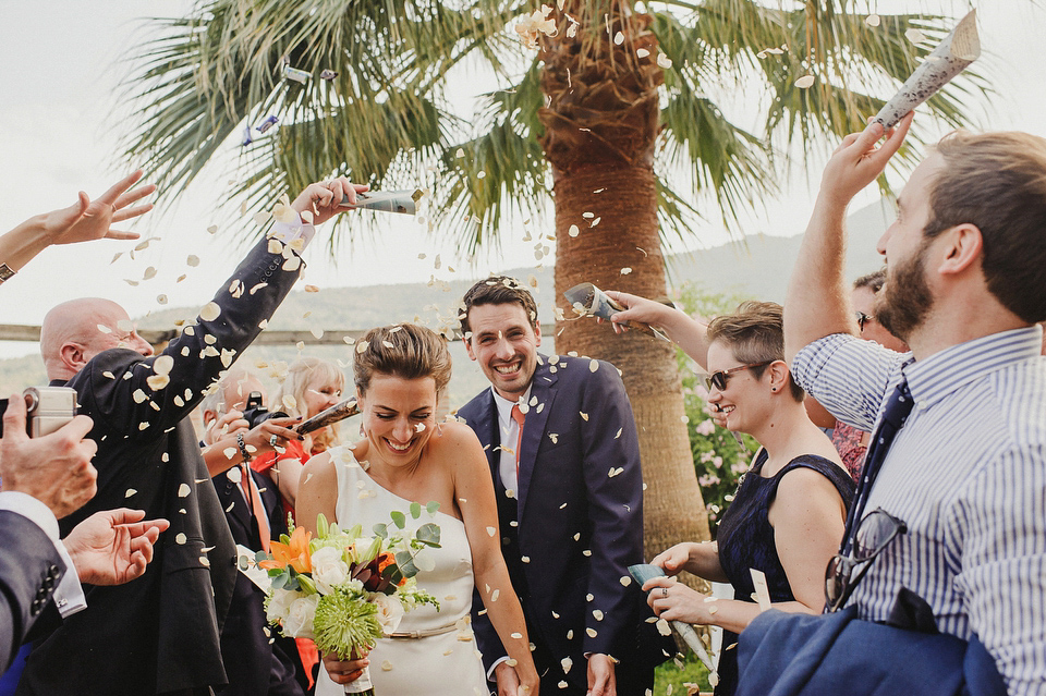 A sophisticated asymmetric dress and sweet first look for a colourful outdoor wedding in Spain. Photography by This Modern Love.