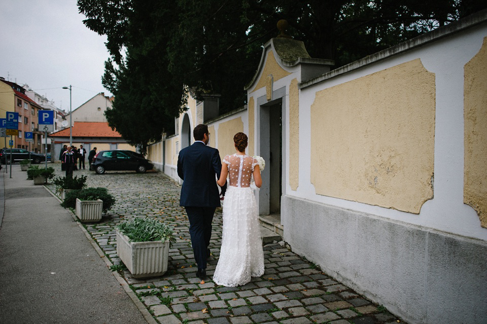 An elegant wedding in Croatia with a bride wearing a dress covered in silk petals and a pug dog in a red bow tie. Photography by Marko Marinkovic.