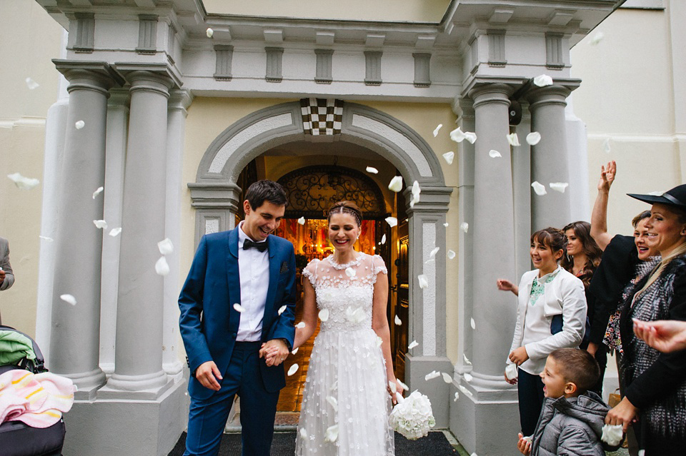 An elegant wedding in Croatia with a bride wearing a dress covered in silk petals and a pug dog in a red bow tie. Photography by Marko Marinkovic.