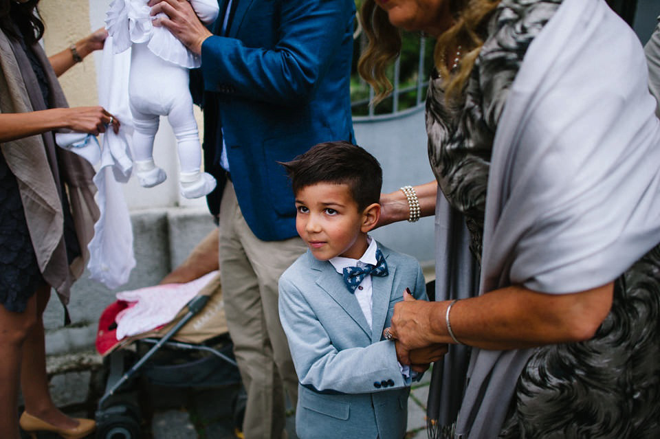 An elegant wedding in Croatia with a bride wearing a dress covered in silk petals and a pug dog in a red bow tie. Photography by Marko Marinkovic.