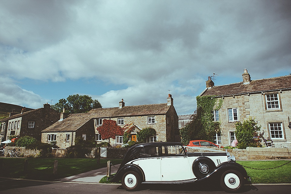 The bride wears a 1950's inspired belted gown by Loulou bridal for her vintage style wedding in North Yorkshire. Photography by Ryan of Shutter Go Click.