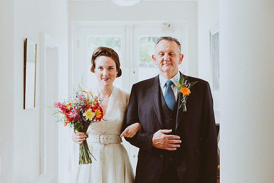 The bride wears a 1950's inspired belted gown by Loulou bridal for her vintage style wedding in North Yorkshire. Photography by Ryan of Shutter Go Click.