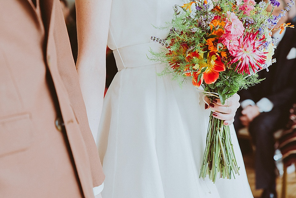 The bride wears a 1950's inspired belted gown by Loulou bridal for her vintage style wedding in North Yorkshire. Photography by Ryan of Shutter Go Click.