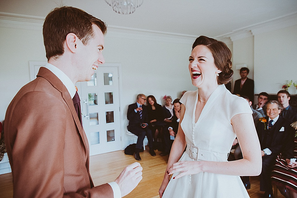 The bride wears a 1950's inspired belted gown by Loulou bridal for her vintage style wedding in North Yorkshire. Photography by Ryan of Shutter Go Click.