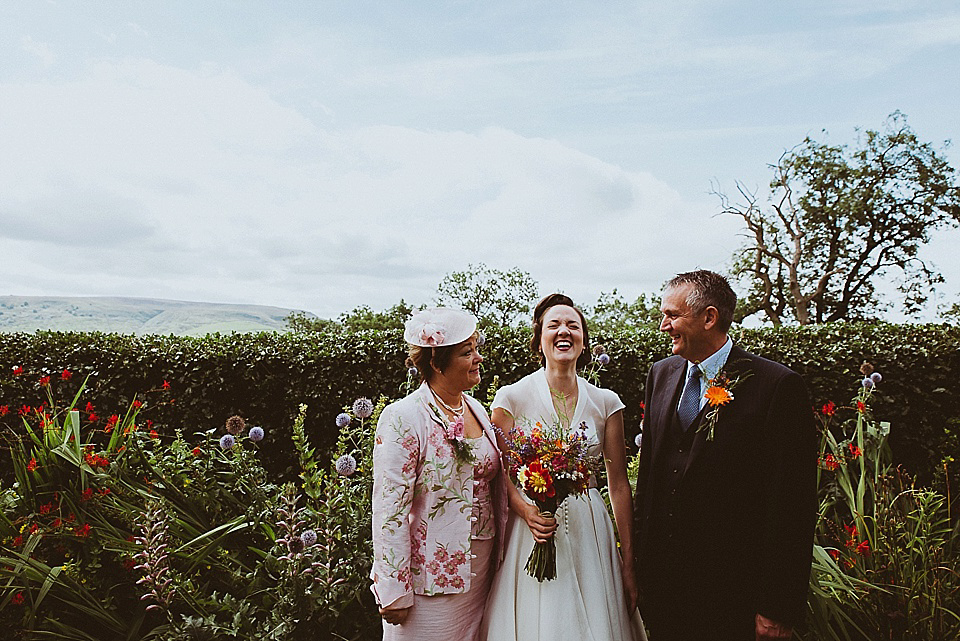 The bride wears a 1950's inspired belted gown by Loulou bridal for her vintage style wedding in North Yorkshire. Photography by Ryan of Shutter Go Click.