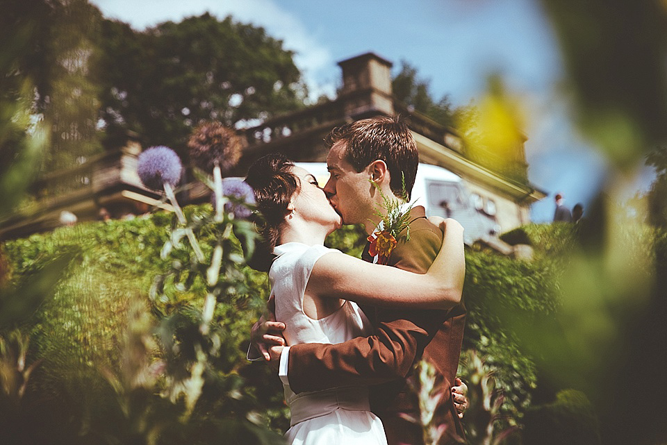 The bride wears a 1950's inspired belted gown by Loulou bridal for her vintage style wedding in North Yorkshire. Photography by Ryan of Shutter Go Click.