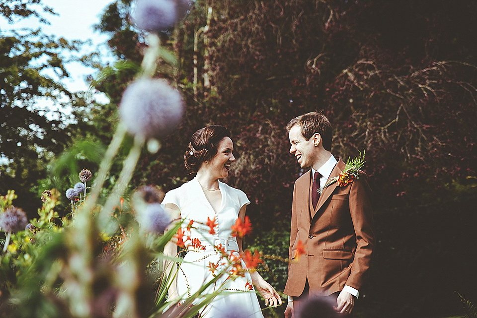 The bride wears a 1950's inspired belted gown by Loulou bridal for her vintage style wedding in North Yorkshire. Photography by Ryan of Shutter Go Click.