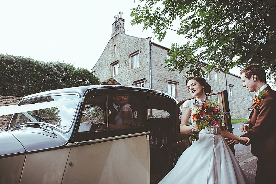 The bride wears a 1950's inspired belted gown by Loulou bridal for her vintage style wedding in North Yorkshire. Photography by Ryan of Shutter Go Click.