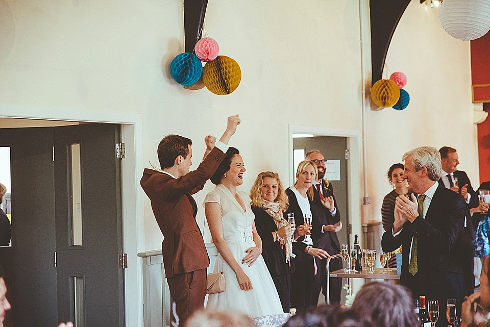 The bride wears a 1950's inspired belted gown by Loulou bridal for her vintage style wedding in North Yorkshire. Photography by Ryan of Shutter Go Click.