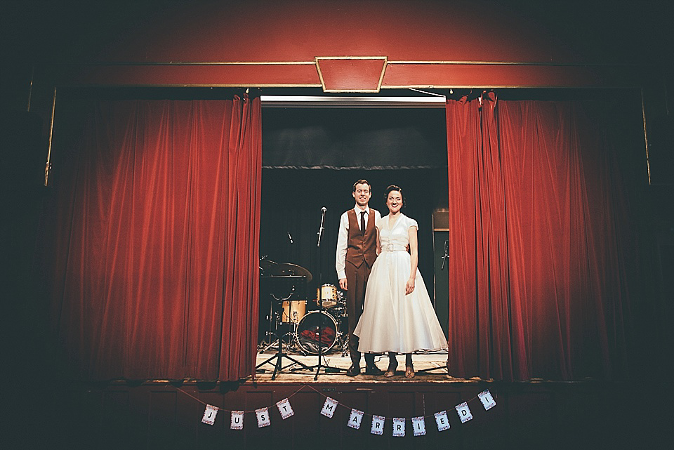 The bride wears a 1950's inspired belted gown by Loulou bridal for her vintage style wedding in North Yorkshire. Photography by Ryan of Shutter Go Click.