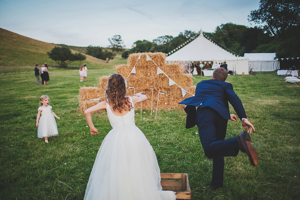 Wildflowers, a meadow, and and elegant Jesus Peiro gown for a handmade summer fete and festival inspired wedding. Photography by Simon Fazackarley.