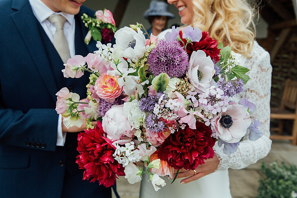 A Charlie Brear gownf for a colourful, flower-filled wedding at Kingscote Barn. Photography by Charlotte Bryer-Ash.