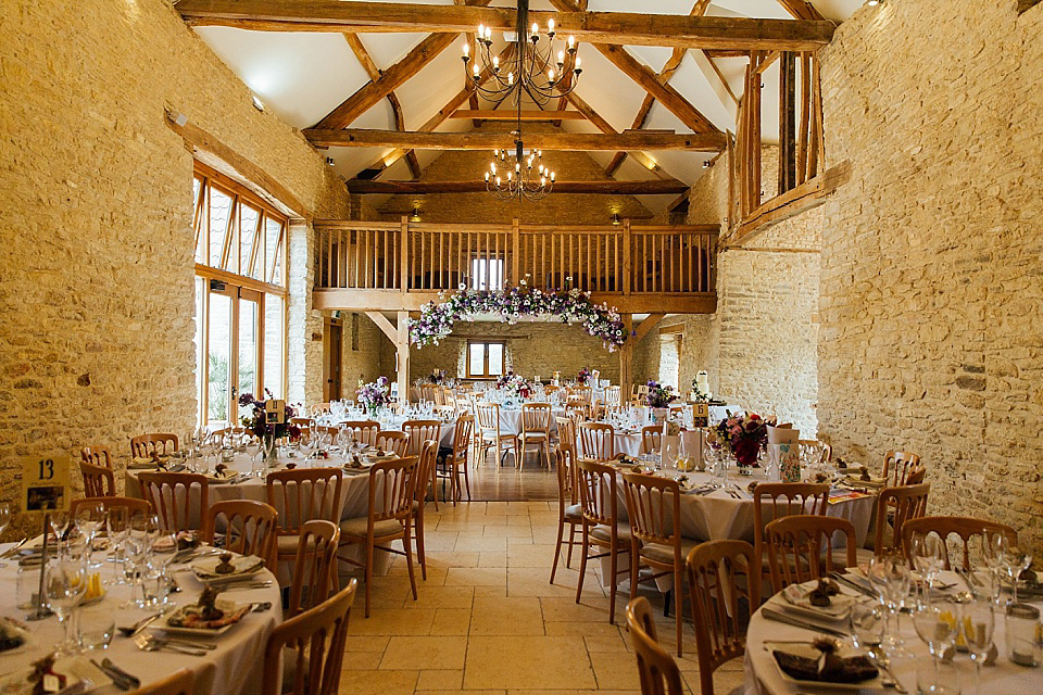 A Charlie Brear gownf for a colourful, flower-filled wedding at Kingscote Barn. Photography by Charlotte Bryer-Ash.