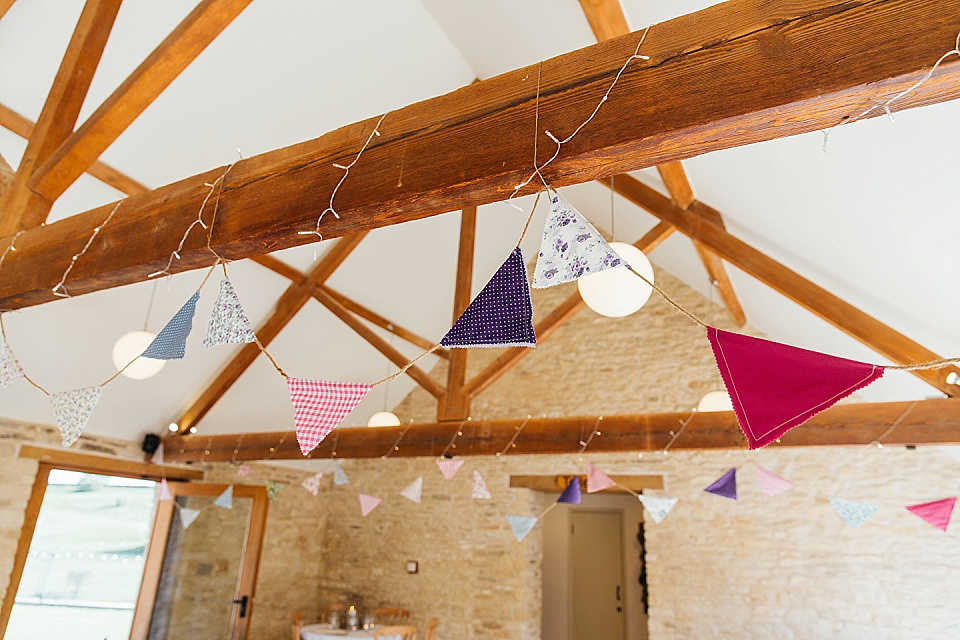 A Charlie Brear gownf for a colourful, flower-filled wedding at Kingscote Barn. Photography by Charlotte Bryer-Ash.