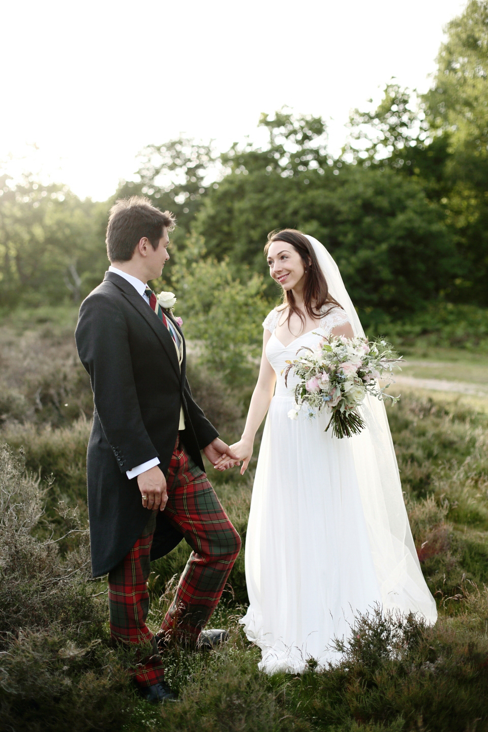 Bride Chloe wore a Suzanne Neville gown which she purchased from Miss Bush Bridal in Surrey, for her military style wedding in the English countryside. Photography by Dasha Caffrey.