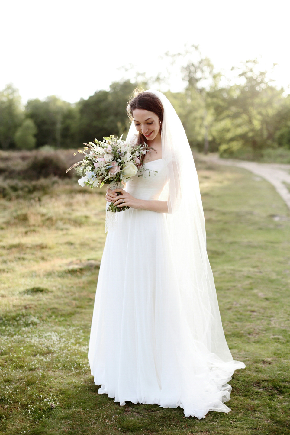 Bride Chloe wore a Suzanne Neville gown which she purchased from Miss Bush Bridal in Surrey, for her military style wedding in the English countryside. Photography by Dasha Caffrey.