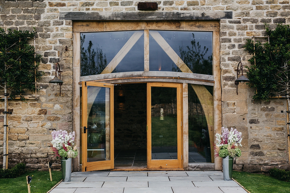 A Suzanne Neville gown and shades fo pink for a colourful wedding at Healey Barn, Northumberland. Photography by John Hope.