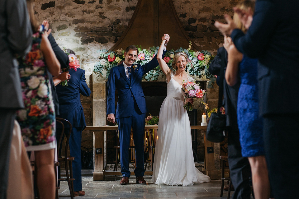 A Suzanne Neville gown and shades fo pink for a colourful wedding at Healey Barn, Northumberland. Photography by John Hope.