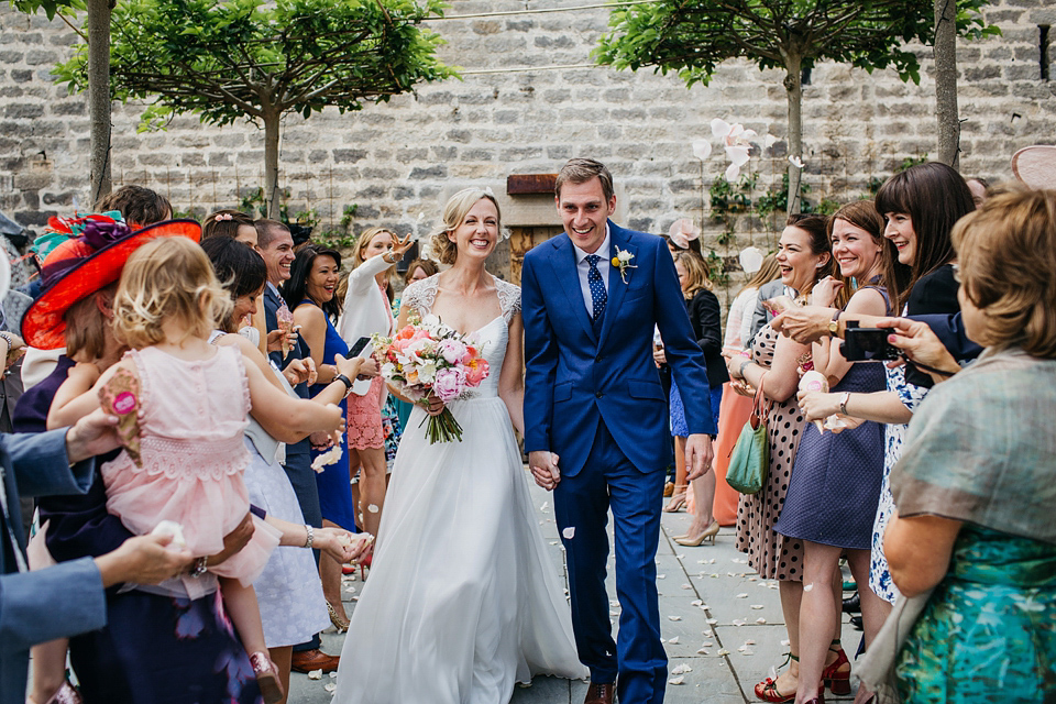 A Suzanne Neville gown and shades fo pink for a colourful wedding at Healey Barn, Northumberland. Photography by John Hope.