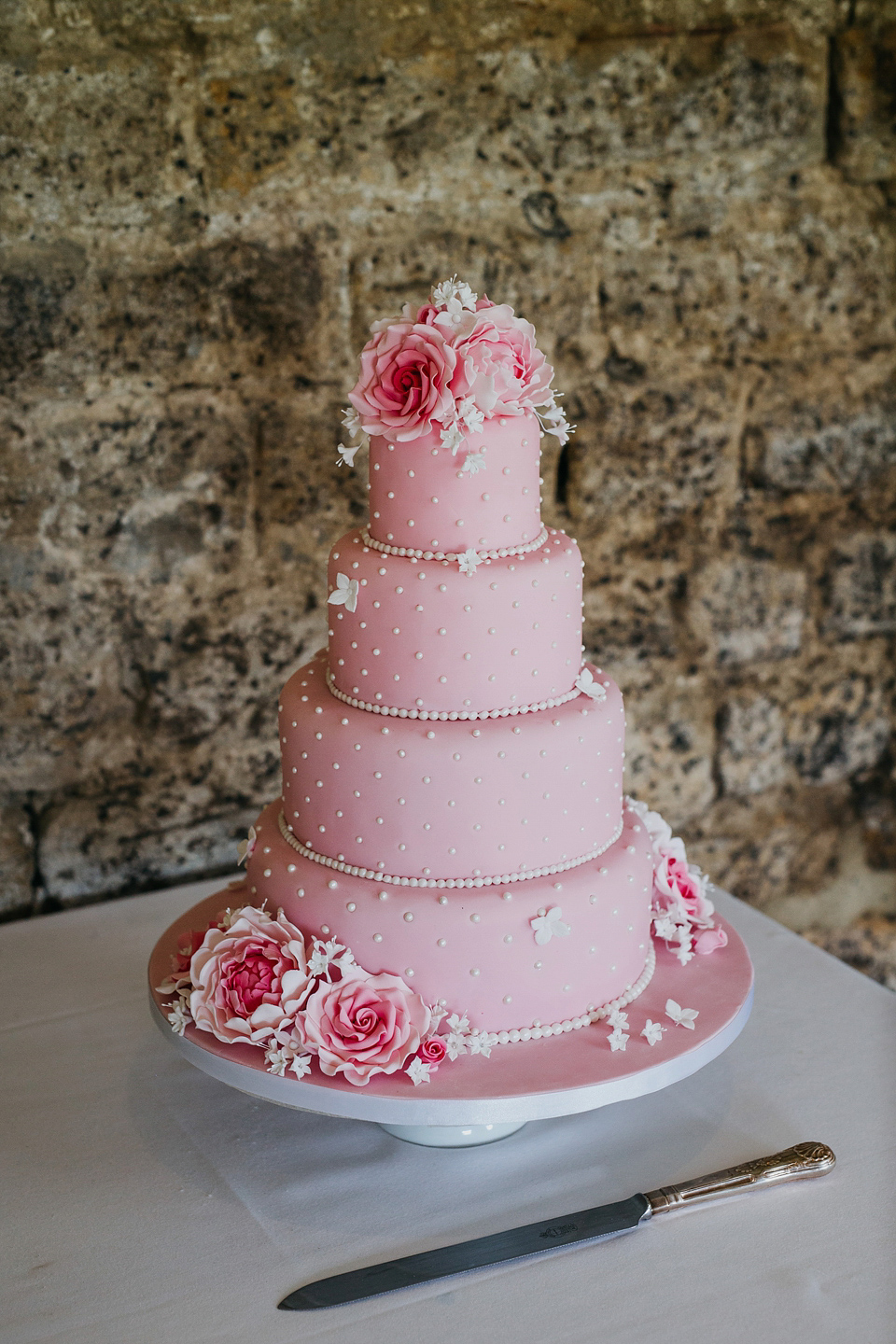 A Suzanne Neville gown and shades fo pink for a colourful wedding at Healey Barn, Northumberland. Photography by John Hope.