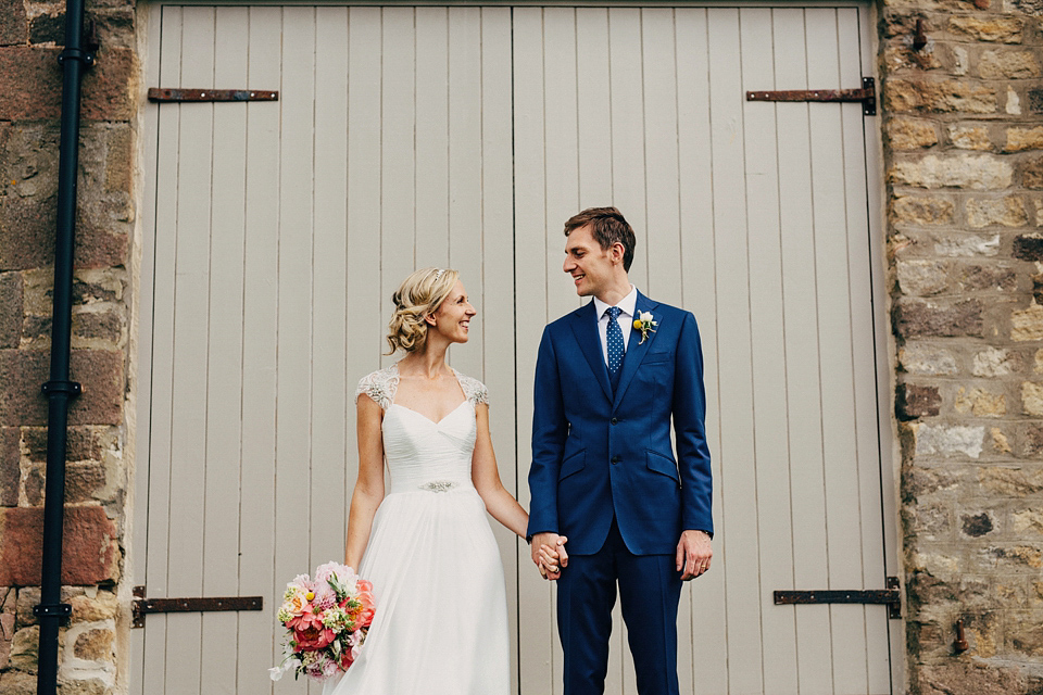 A Suzanne Neville gown and shades fo pink for a colourful wedding at Healey Barn, Northumberland. Photography by John Hope.