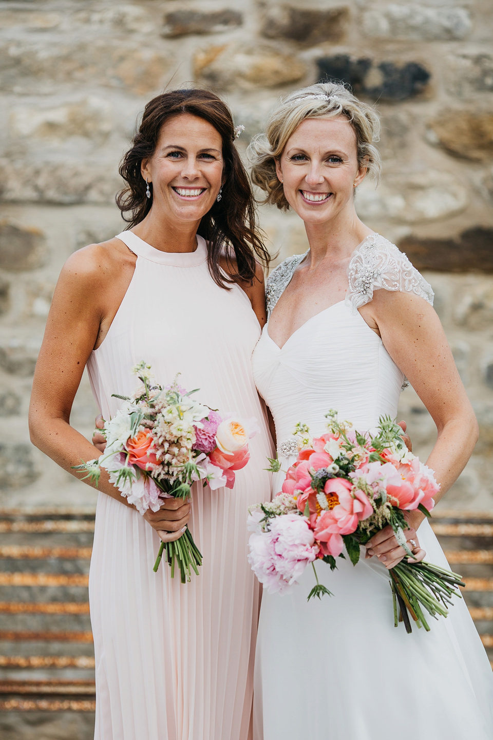 A Suzanne Neville gown and shades fo pink for a colourful wedding at Healey Barn, Northumberland. Photography by John Hope.