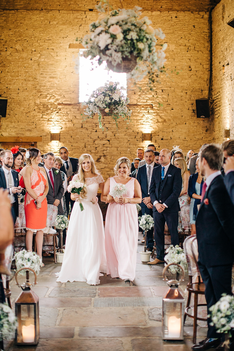 Bride Melanie wears the 'fleur' gown by Naomi Neoh for her Cripps Barn wedding. Her bridesmaids are most pretty in soft pink by 'For Her & For Him'. Images by M&J Photography.