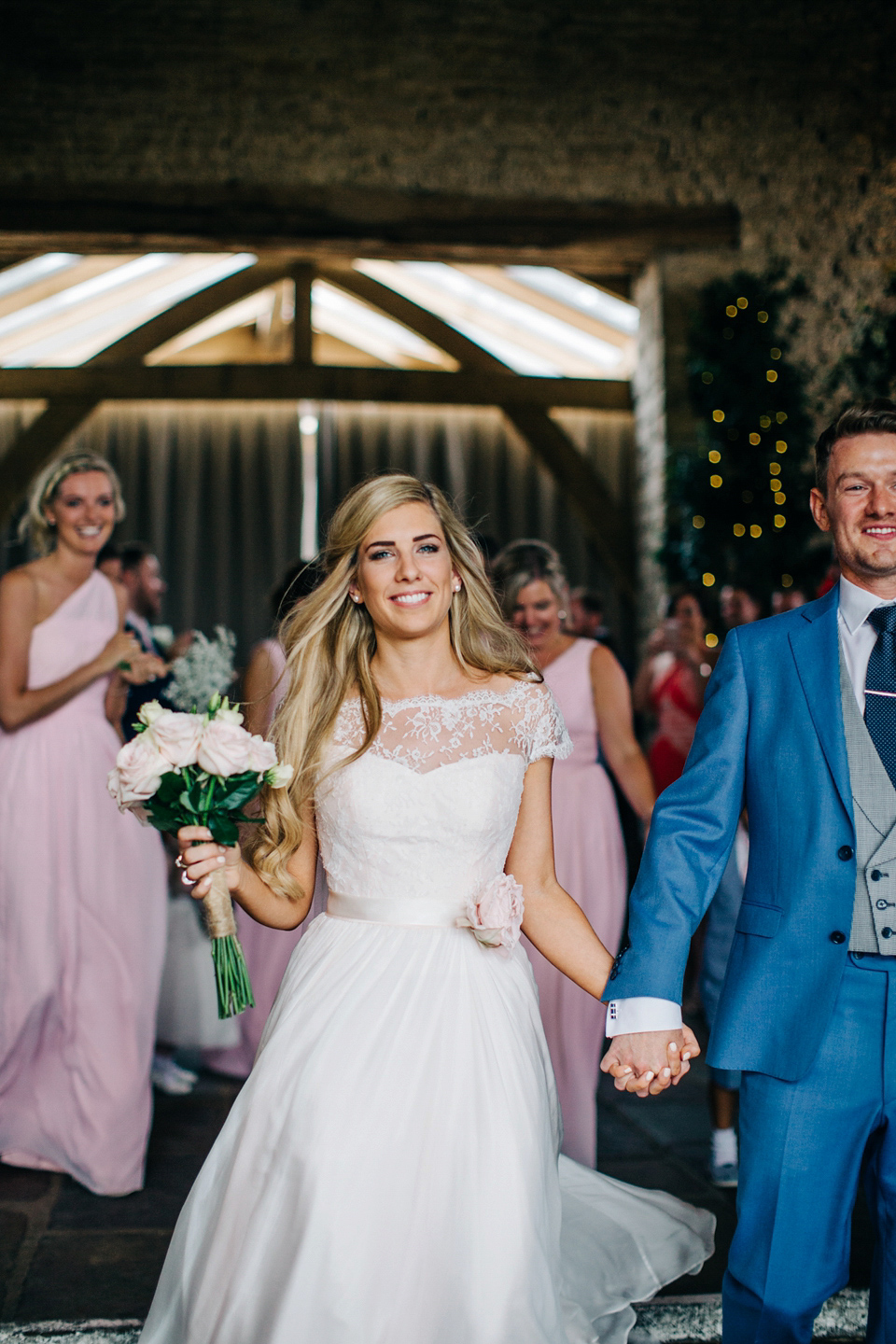 Bride Melanie wears the 'fleur' gown by Naomi Neoh for her Cripps Barn wedding. Her bridesmaids are most pretty in soft pink by 'For Her & For Him'. Images by M&J Photography.