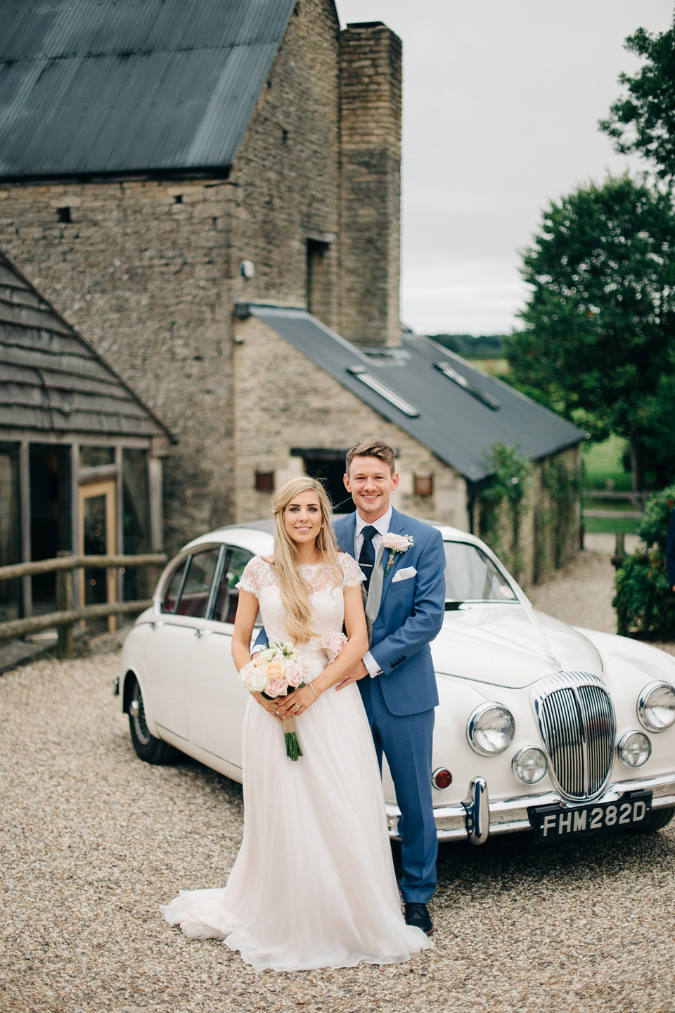 Bride Melanie wears the 'fleur' gown by Naomi Neoh for her Cripps Barn wedding. Her bridesmaids are most pretty in soft pink by 'For Her & For Him'. Images by M&J Photography.