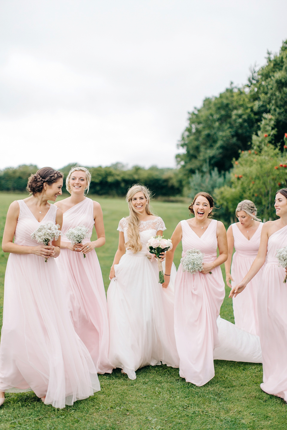 Bride Melanie wears the 'fleur' gown by Naomi Neoh for her Cripps Barn wedding. Her bridesmaids are most pretty in soft pink by 'For Her & For Him'. Images by M&J Photography.